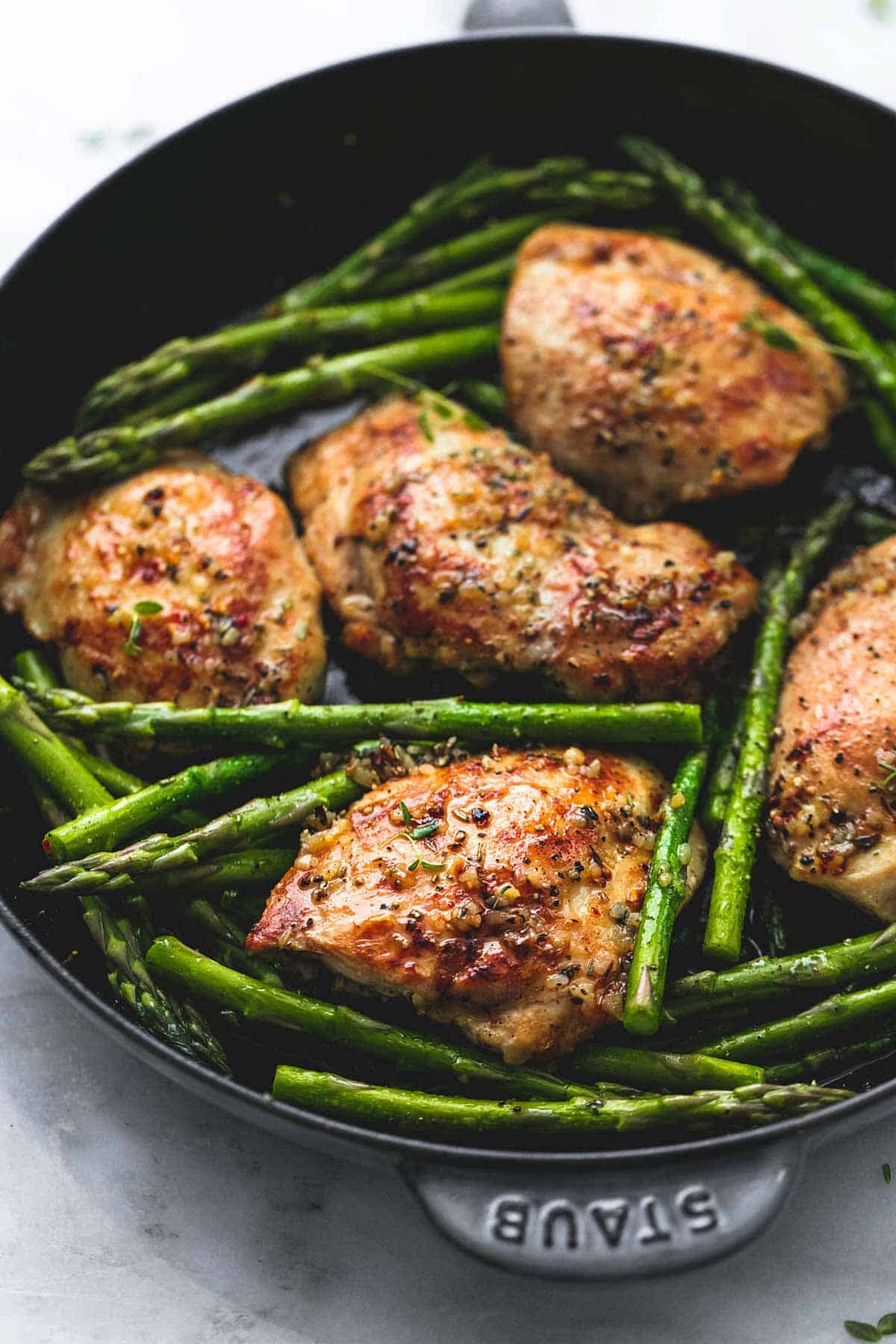 garlic herb chicken and asparagus in a pan.