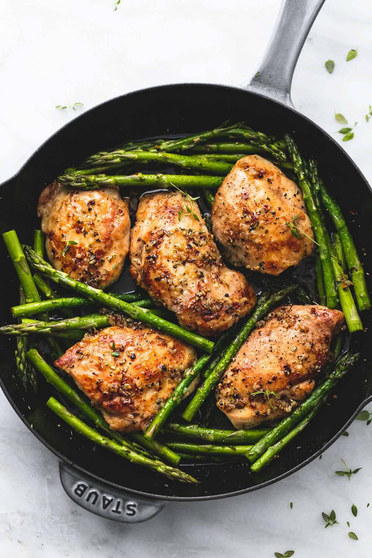 top view of garlic herb chicken and asparagus in a pan.