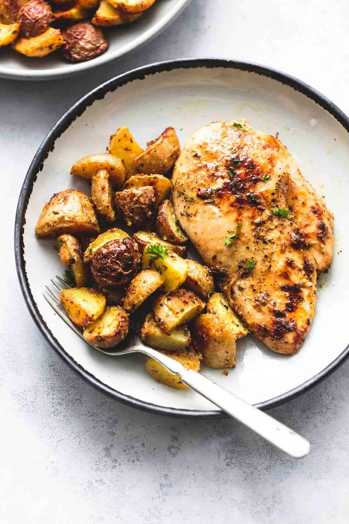 sheet pan chicken and potatoes with a fork on a plate.