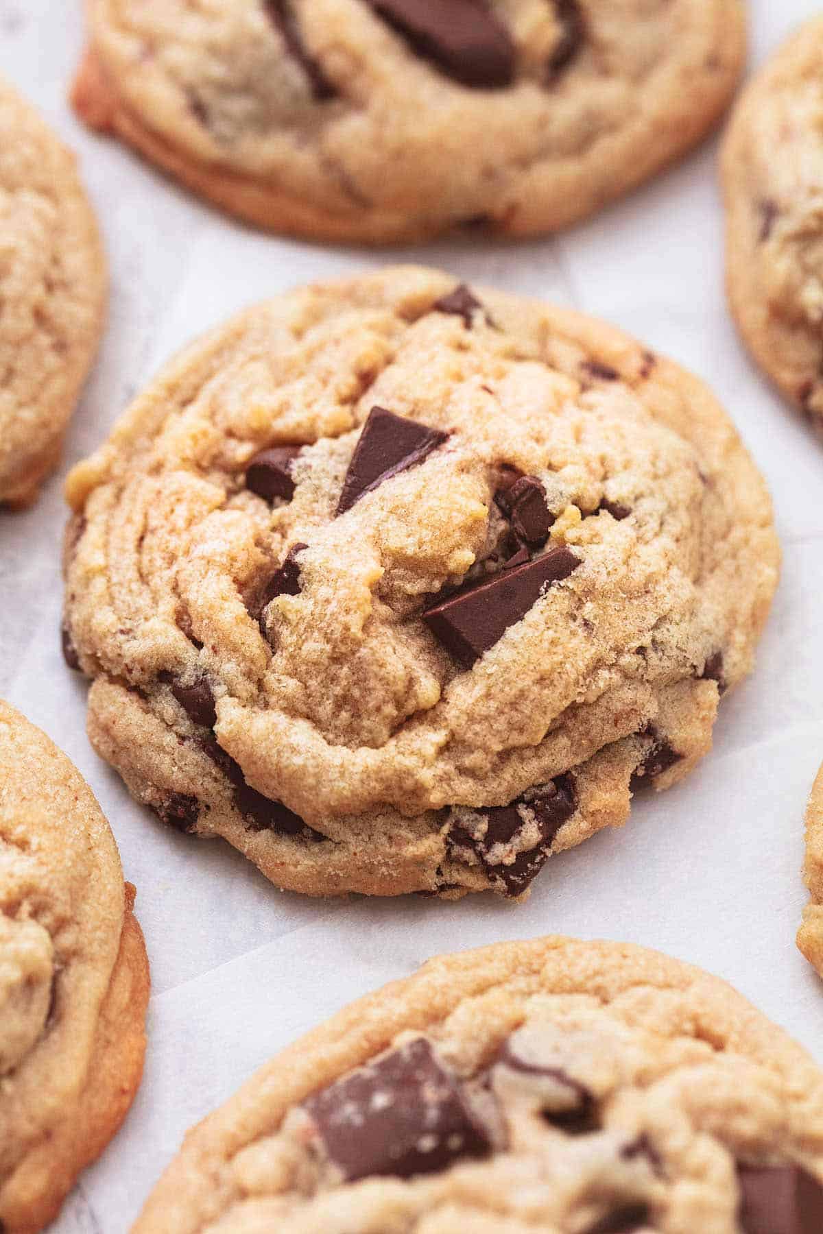 close up of a peanut butter chocolate chunk cookie with more cookies around it.