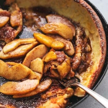 3/4 of a skillet with apple dutch baby and fork digging into pancake