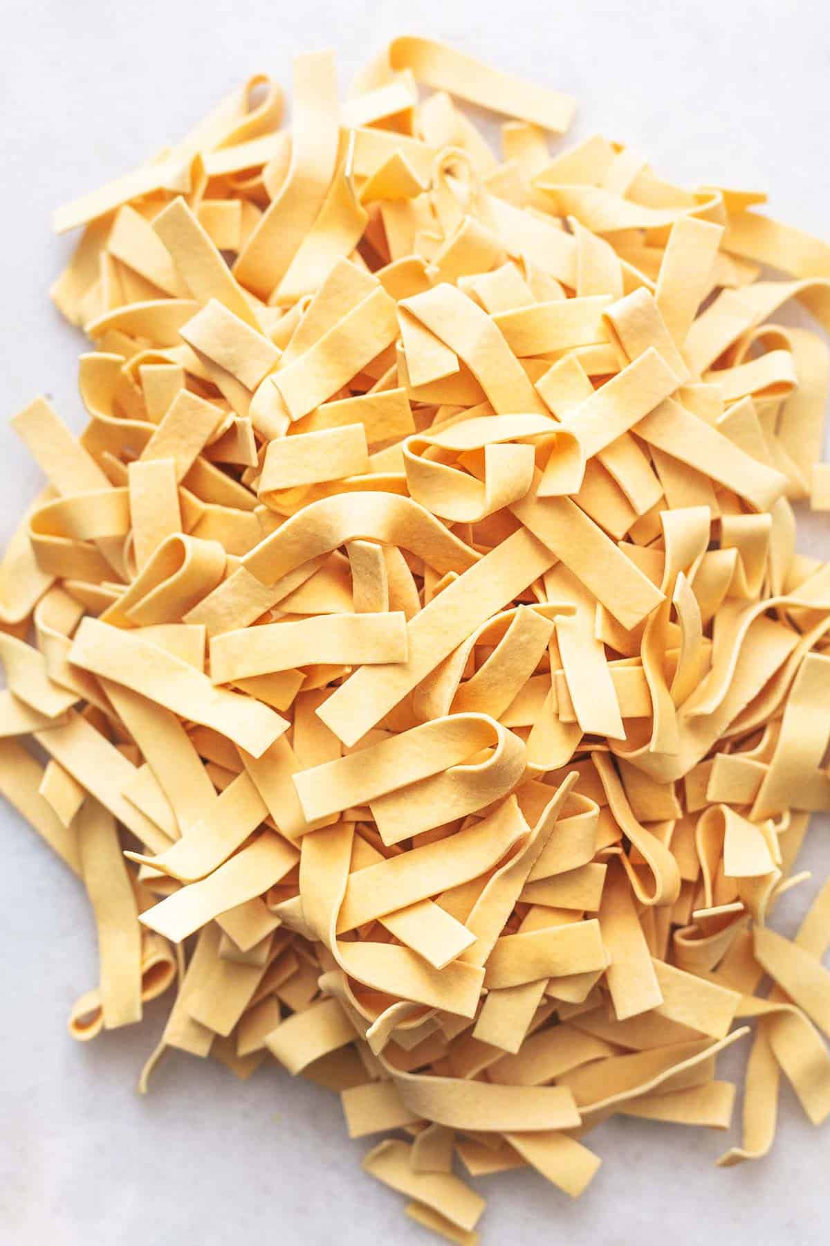 dry egg noodles in a pile on marble tabletop