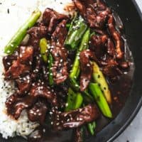 up close view of beef strips with green onions and rice topped with sesame seeds