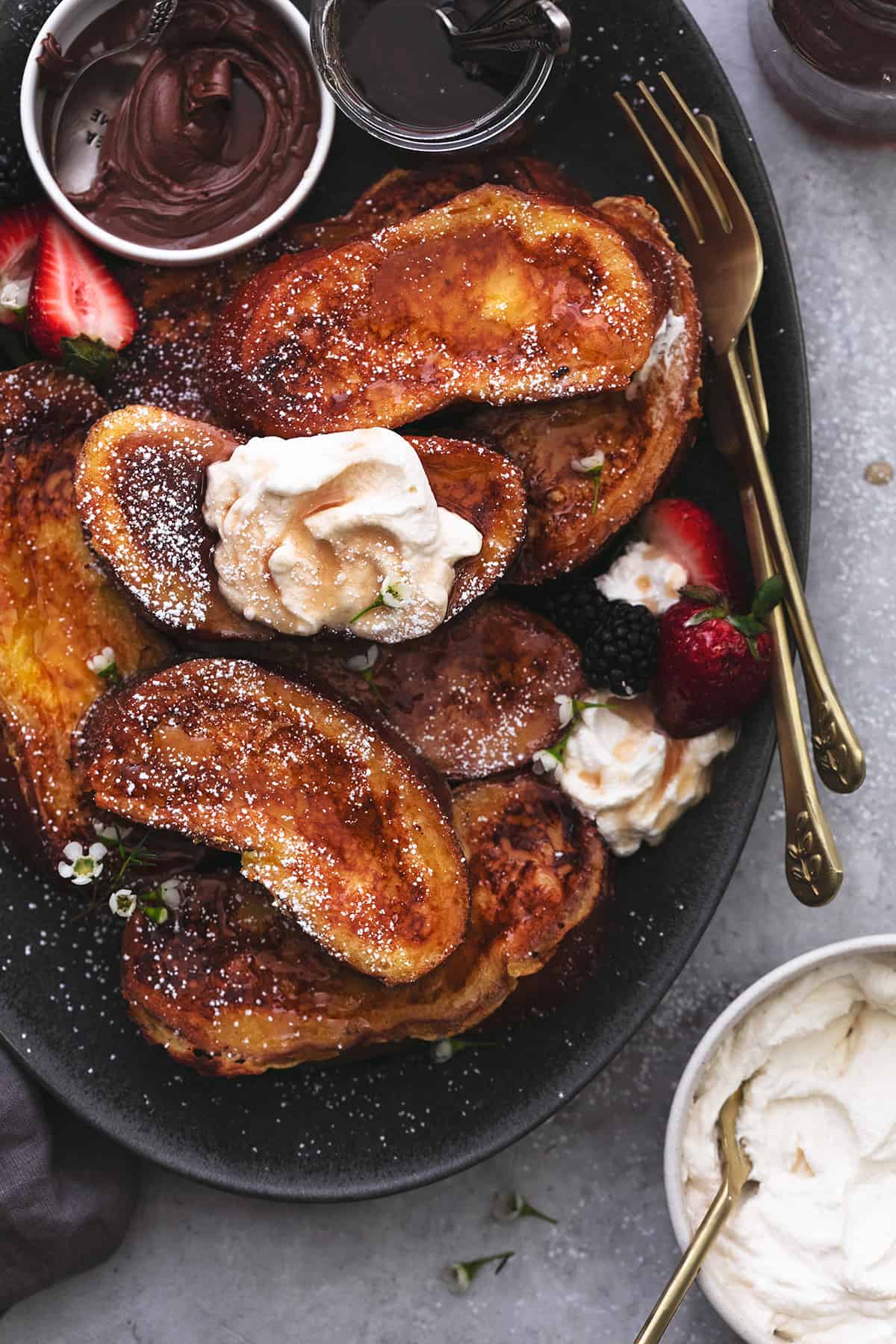 french toast with whipped cream and syrup on serving platter