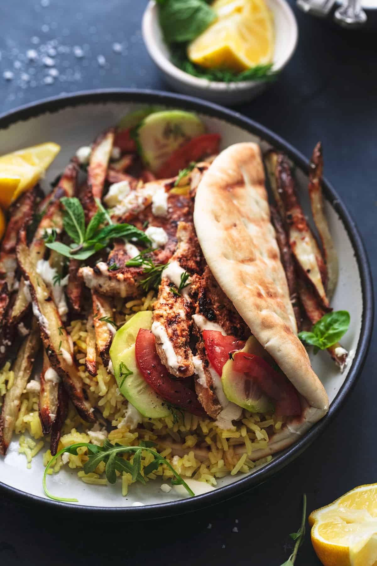 greek chicken gyro with rice and potatoes on plate