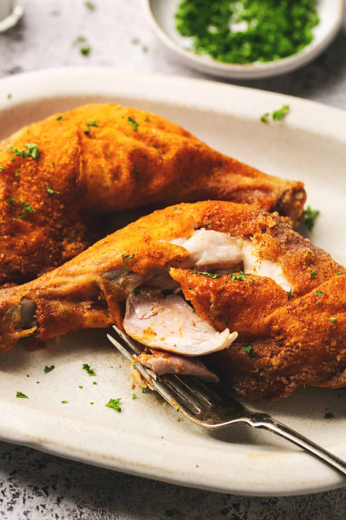 fork pulling apart fried chicken leg