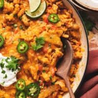 mexican chicken and rice casserole in skillet with wooden spoon