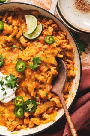 mexican chicken and rice casserole in skillet with wooden spoon