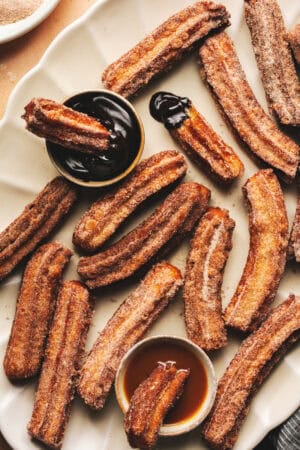 churros on a platter with chocolate dipping sauce
