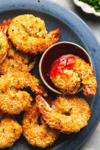 baked coconut shrimp on plate with sweet and sour sauce in cup