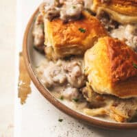 up close breakfast casserole with biscuits and sausage gravy on plate