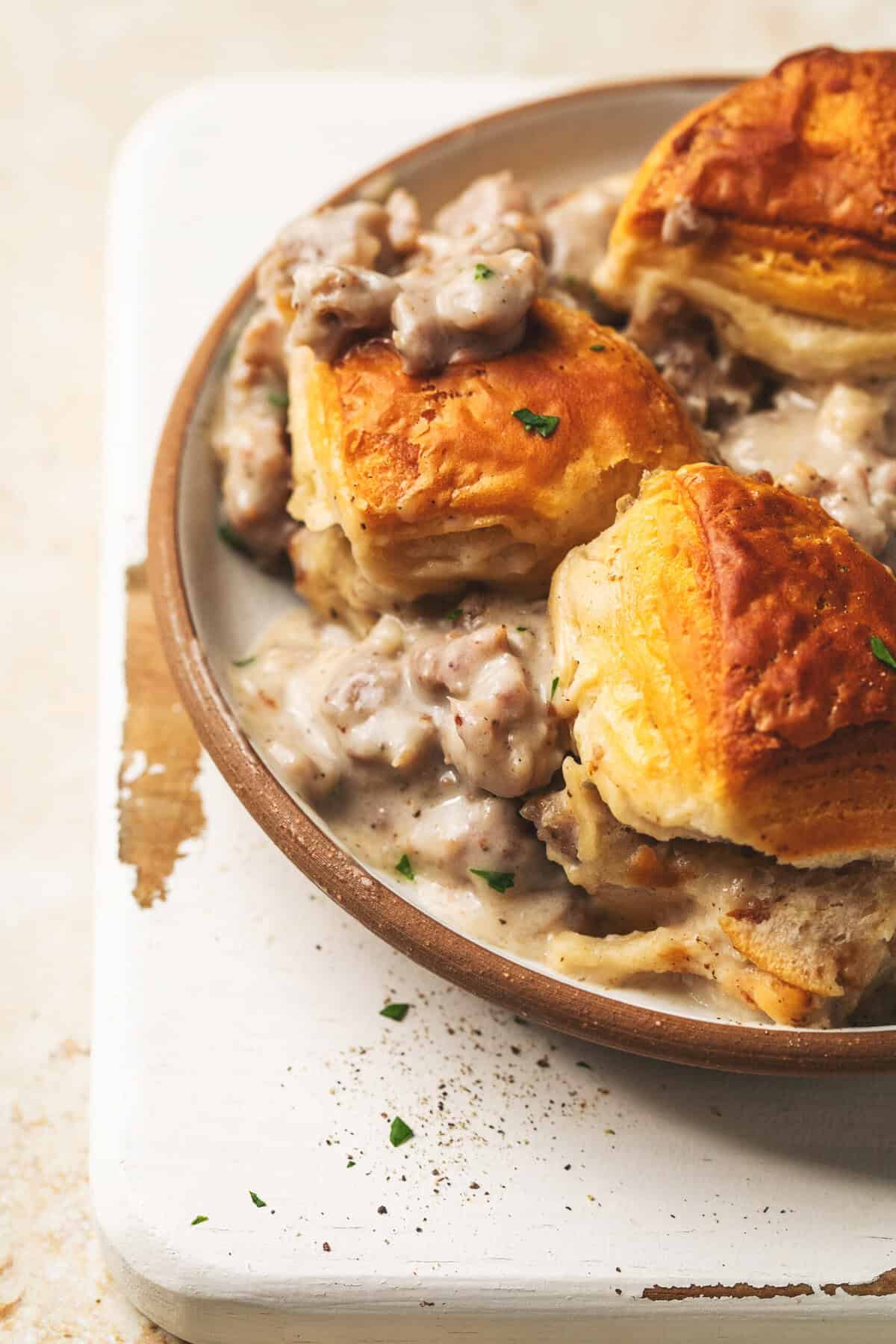 up close breakfast casserole with biscuits and sausage gravy on plate