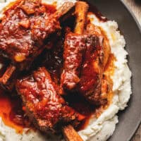 beef short ribs with gravy over mashed potatoes in bowl