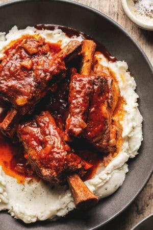 beef short ribs with gravy over mashed potatoes in bowl