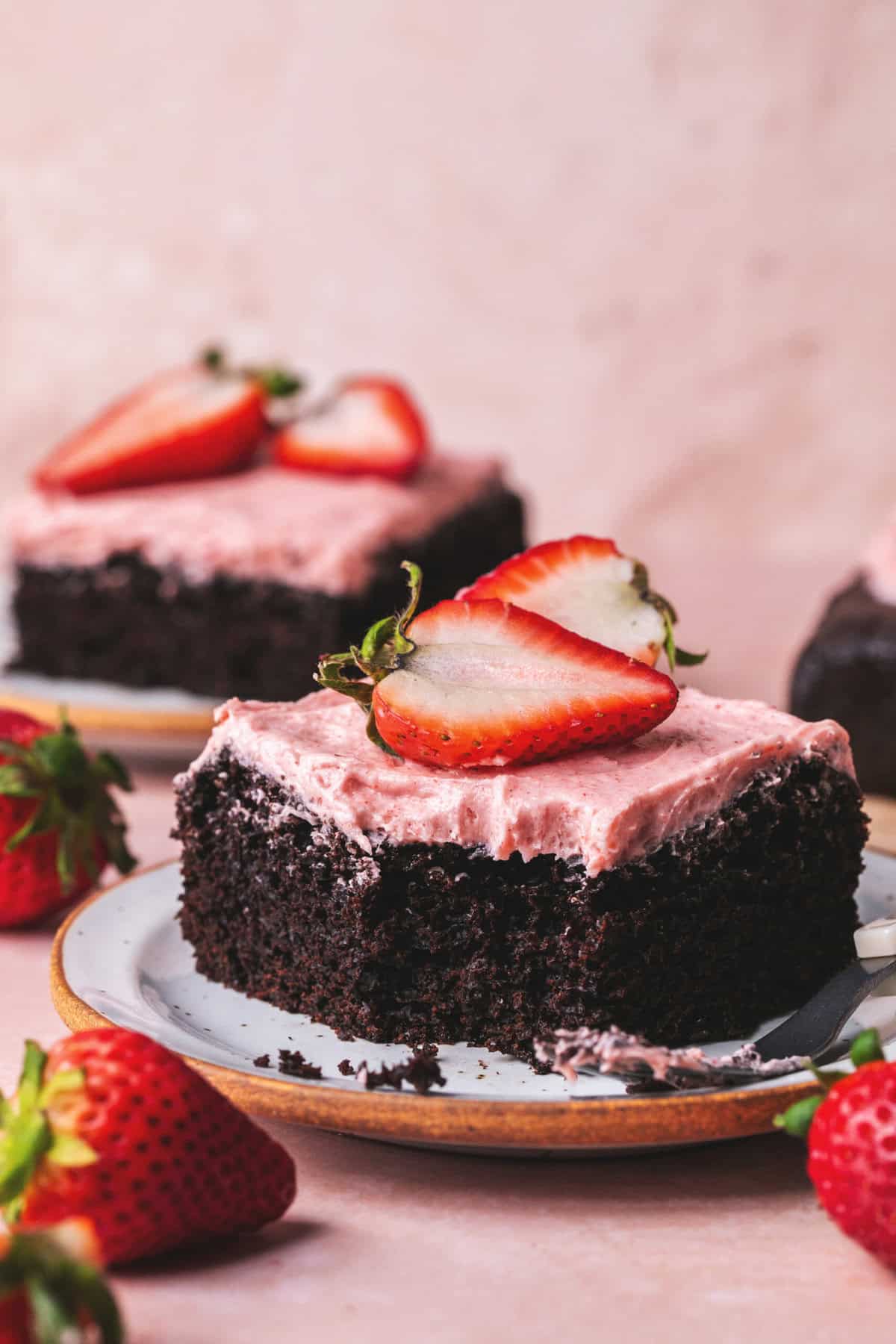 piece of chocolate cake with strawberry frosting and strawberries