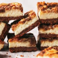 stacked cheesecake bars on parchment paper