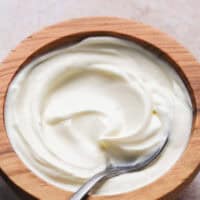 sour cream in wooden bowl with spoon