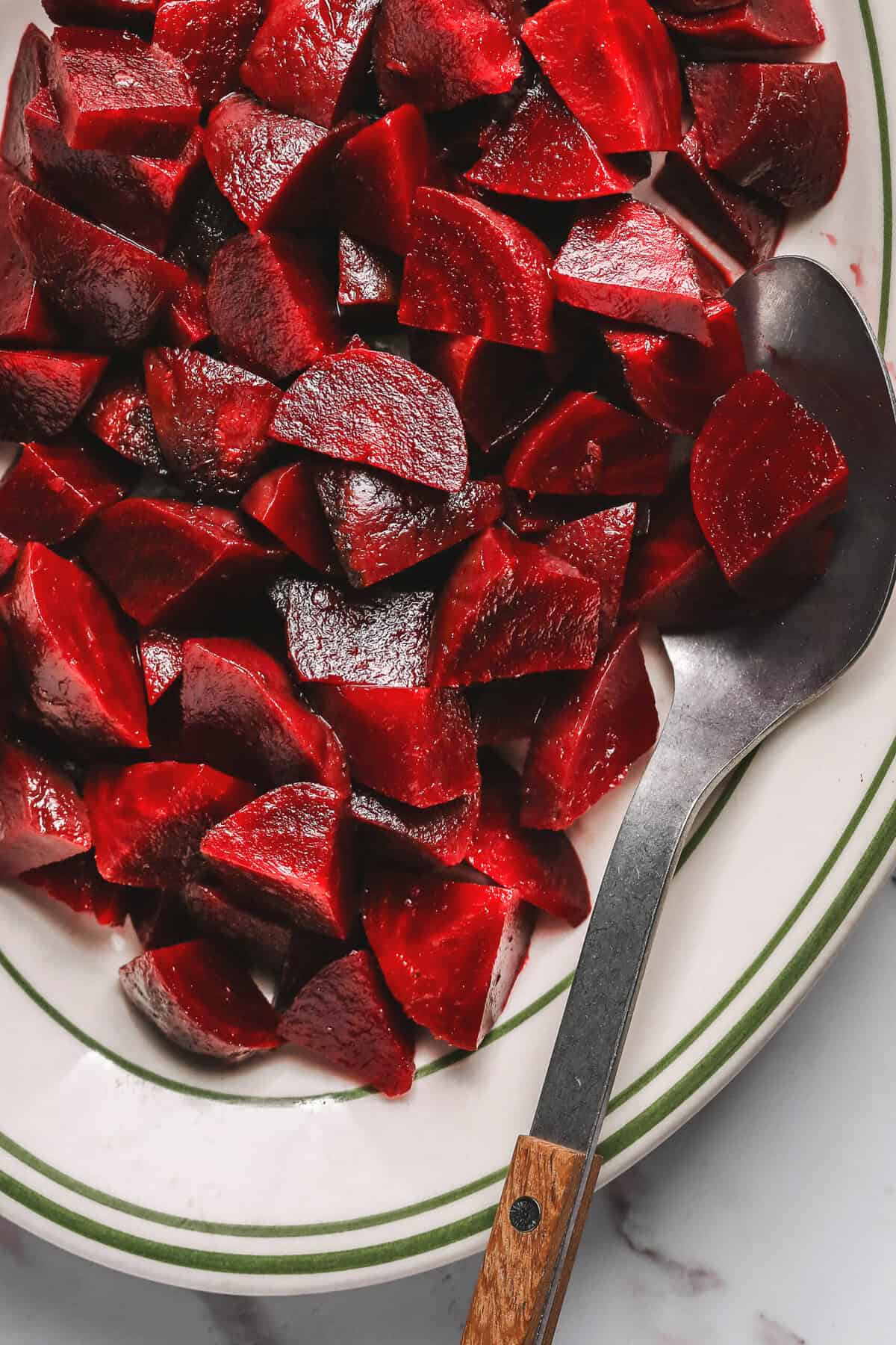 chopped, roasted beets with metal serving spoon