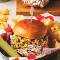 shredded chicken and stuffing sandwich with pickle and chips in basket