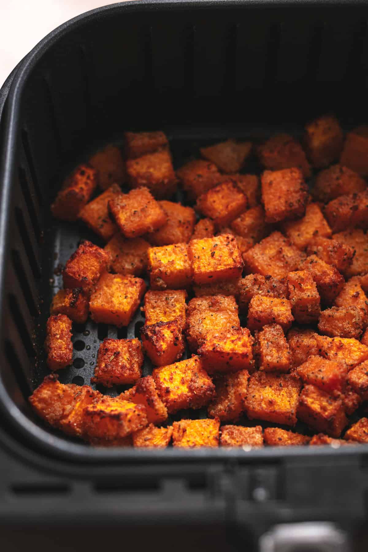 cubed and cooked butternut squash in air fryer basket