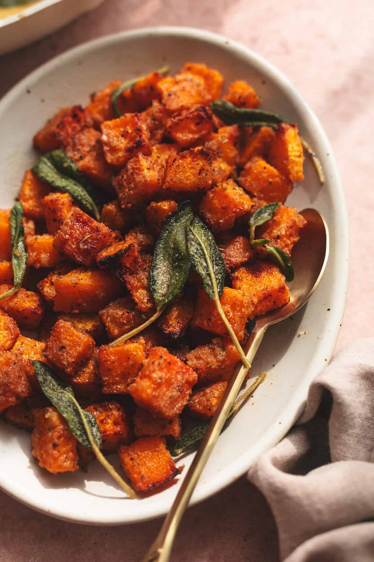 roasted butternut squash with butter and sage on platter