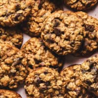 oatmeal cookies with chocolate chips overlapping and piled on tabletop