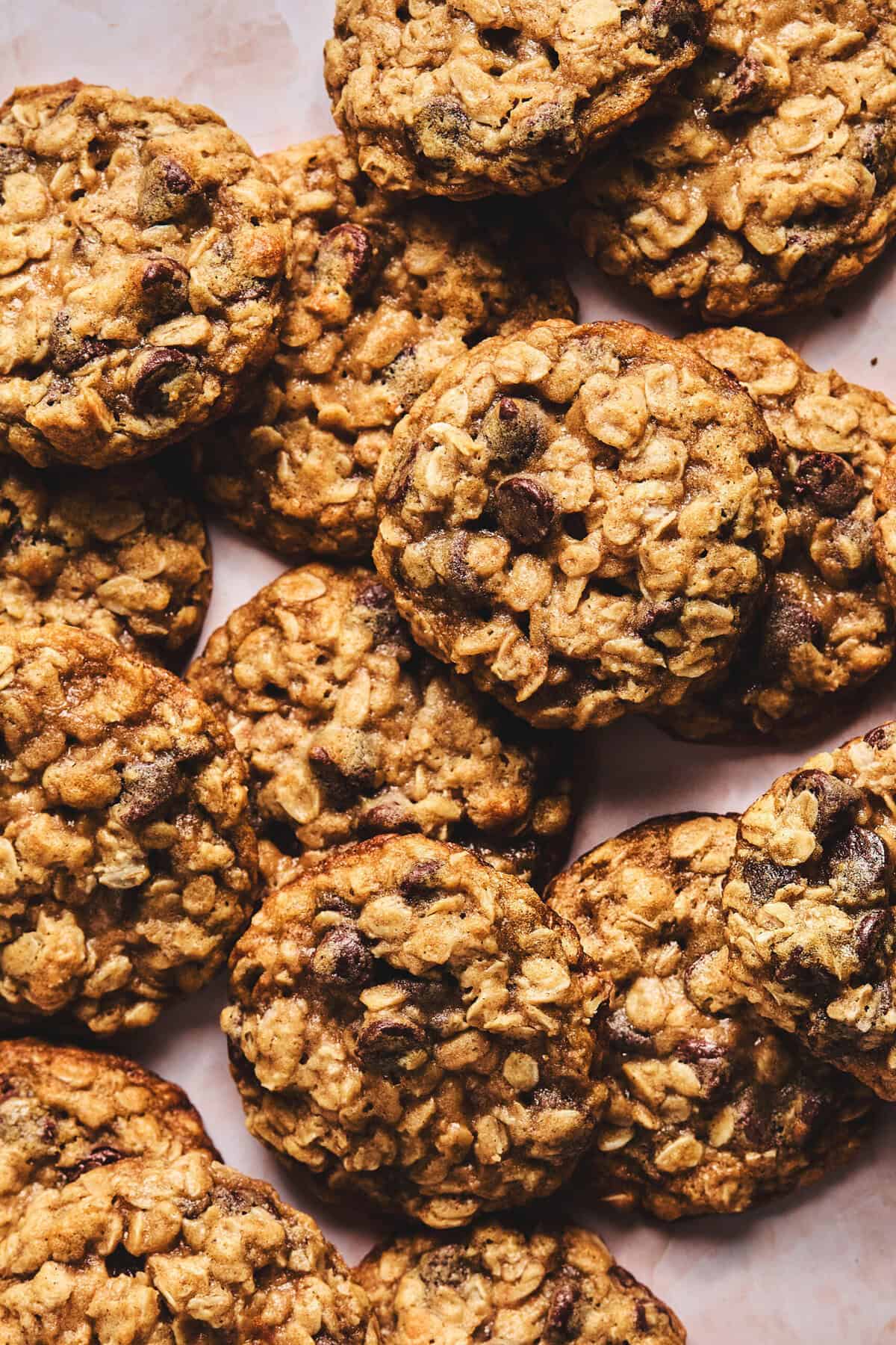 oatmeal cookies with chocolate chips overlapping and piled on tabletop