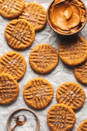 peanut butter cookies on table with sea salt flakes and peanut butter