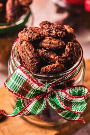 cinnamon pecans in a jar tied with a holiday ribbon