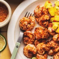 air fryer shrimp with mango salsa and fork on plate