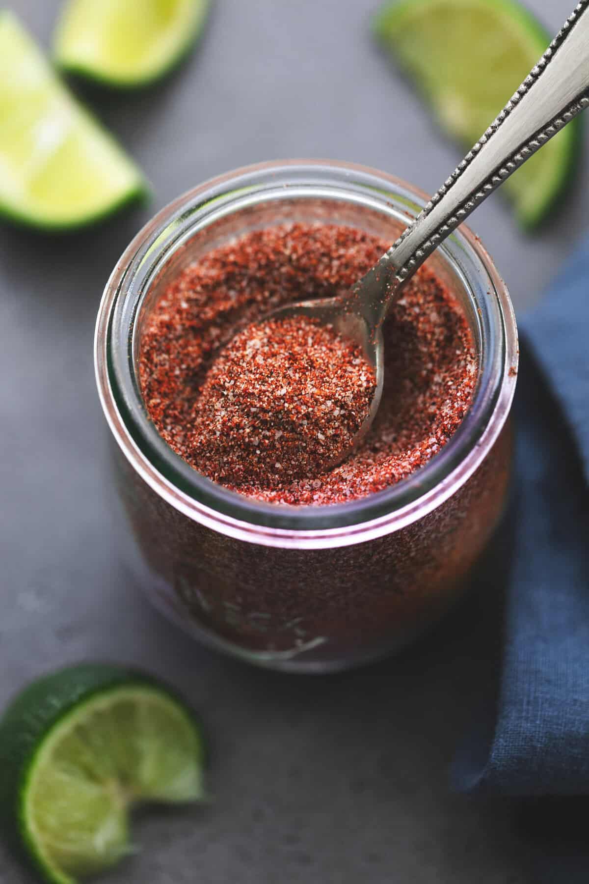 spoon scooping fajita seasoning spices from a jar