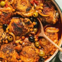 moroccan chicken tagine in skillet with wooden serving spoon