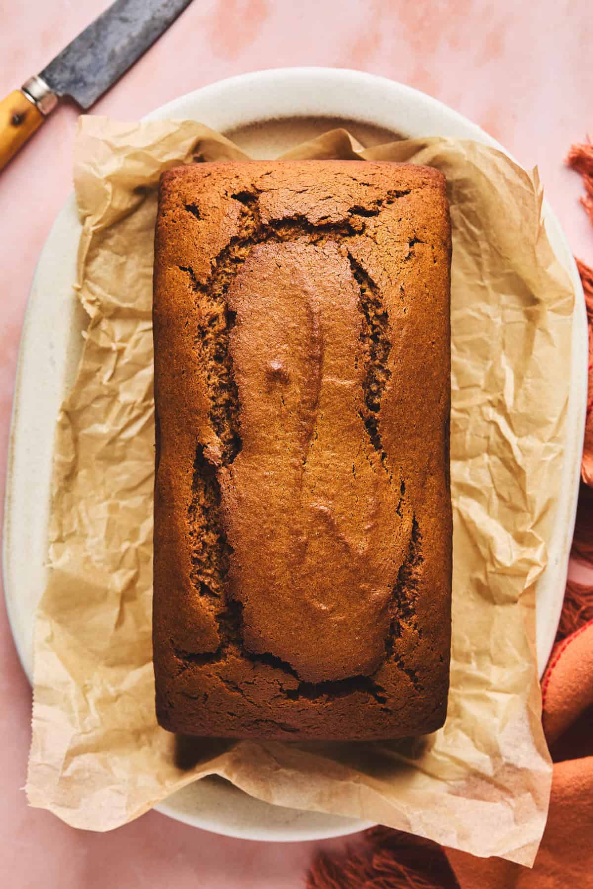 un-cut loaf of sweet potato bread on parchment paper