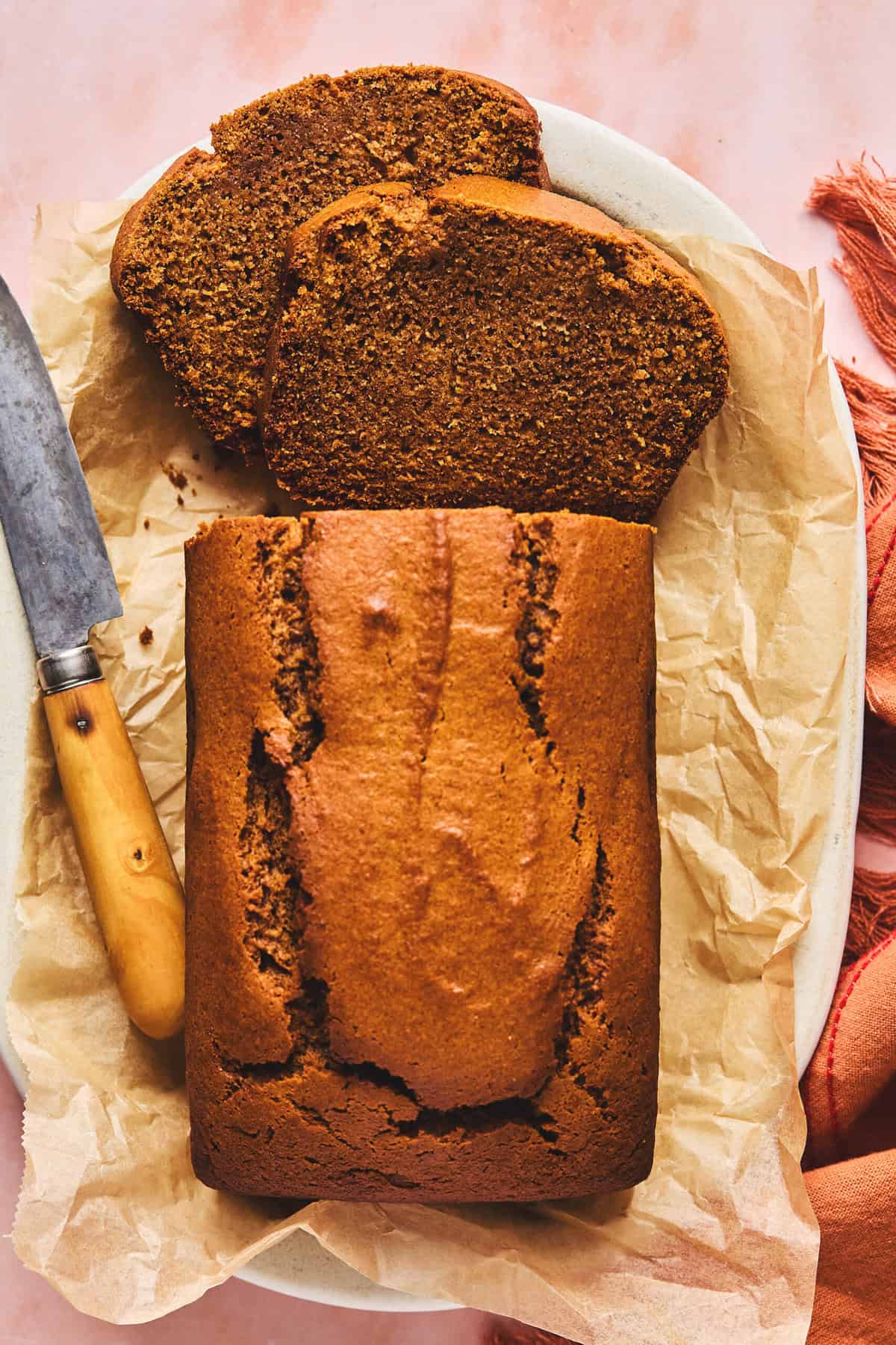 overhead view of loaf of sweet potato bread partially cut with knife