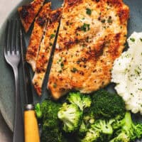 pan fried chicken breast sliced on plate with broccoli and potatoes