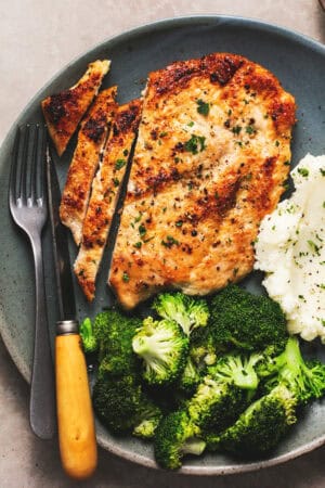 pan fried chicken breast sliced on plate with broccoli and potatoes